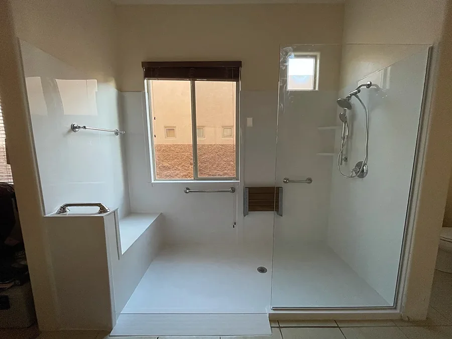 Barrier-free roll-in shower with grab bars and a built-in seat